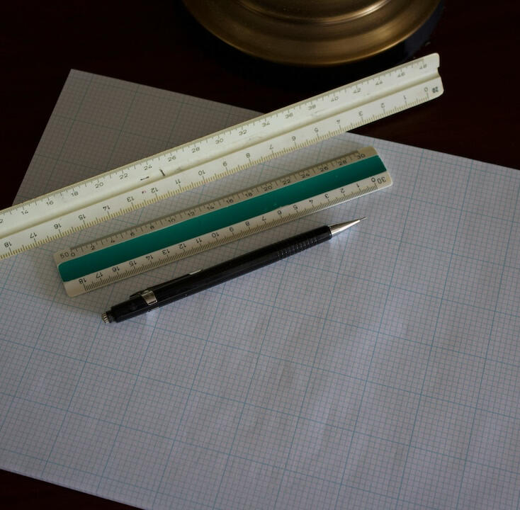 Photo of some graph paper on a desk with pencil and rules on it