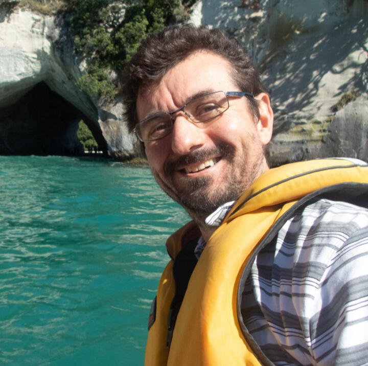 A photograph of Duncan out on the water wearing a lifejacket on a beautiful sunny NZ day.